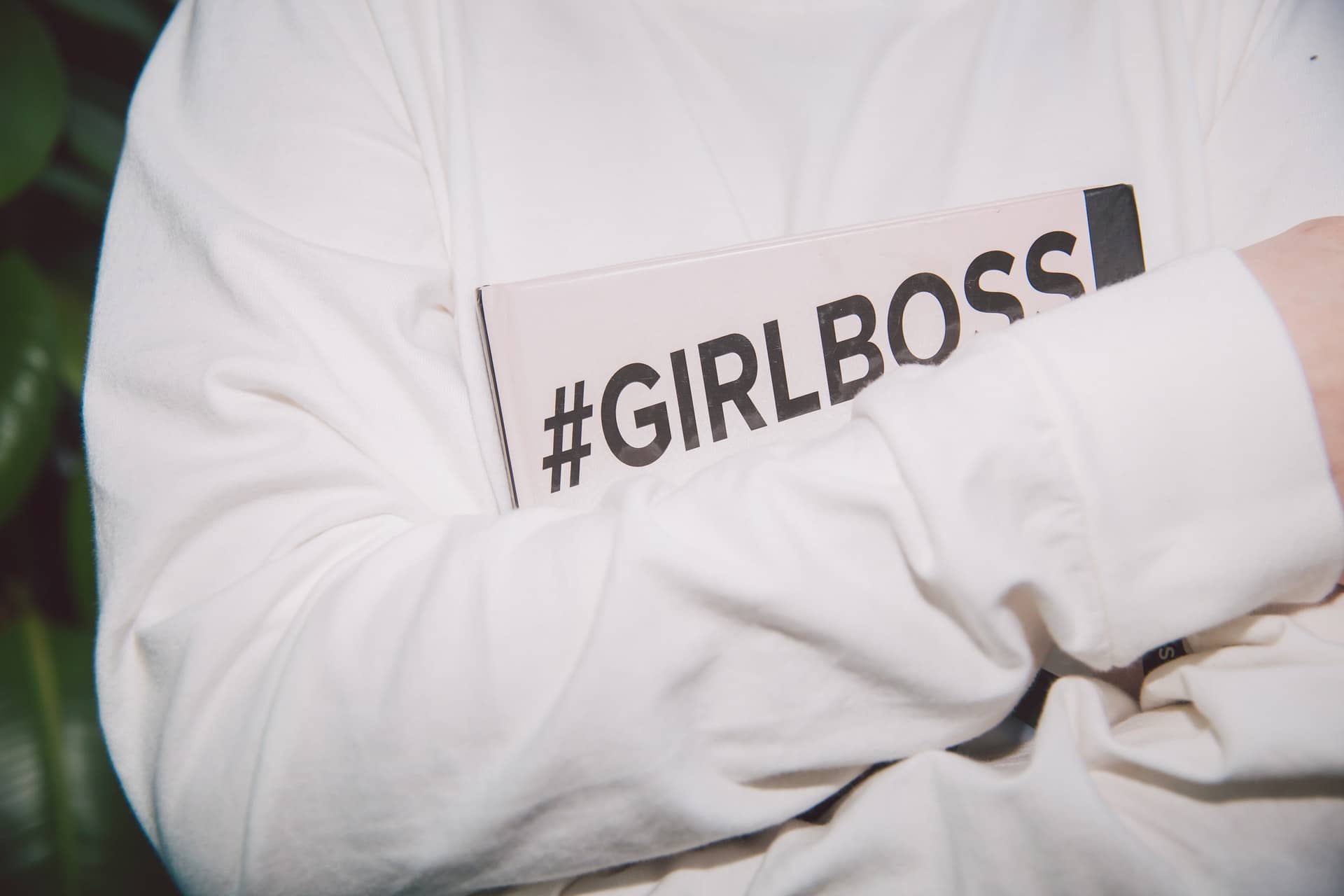 Girl holding a book having #GirlBoss hashtag on its cover